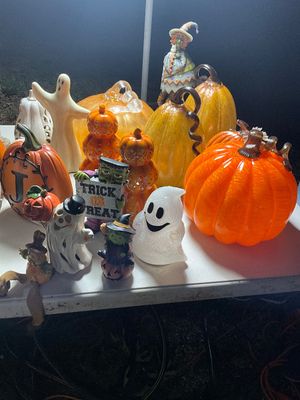 Sale Photo Thumbnail #23: Collection of Halloween decor items, including blown glass pumpkins, ceramic ghost figurines, and a Frankenstein 'Trick or Treat' statue.