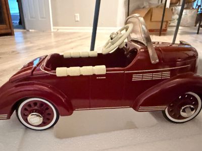 Sale Photo Thumbnail #30: Vintage-style burgundy pedal car with white wall tires, steering wheel, and silver windshield frame.