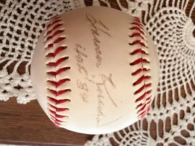 Sale Photo Thumbnail #38: Autographed baseball featuring a faded signature in ink across the sweet spot, rest on a lace doily.