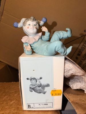 Sale Photo Thumbnail #36: Lladró porcelain figurine 'Pequeño bufón acostado' (Little Lying Jester) #1066, depicting a reclining harlequin in a light blue suit, complete with original box.