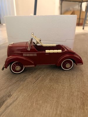 Sale Photo Thumbnail #28: Vintage-style maroon die-cast model pedal car, featuring chrome trim and whitewall tires in clean condition.
