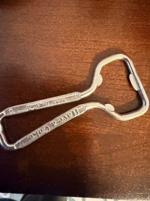 Sale Photo Thumbnail #18: Vintage metal Coca-Cola bottle opener embossed with 'Drink Coca-Cola' and 'Have a Coke' text.