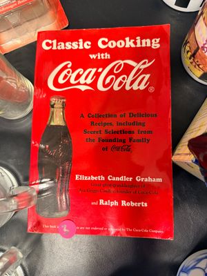 Sale Photo Thumbnail #15: "Classic Cooking with Coca-Cola" paperback cookbook by Elizabeth Candler Graham and Ralph Roberts, featuring a bright red cover with iconic Coca-Cola bottle graphic.