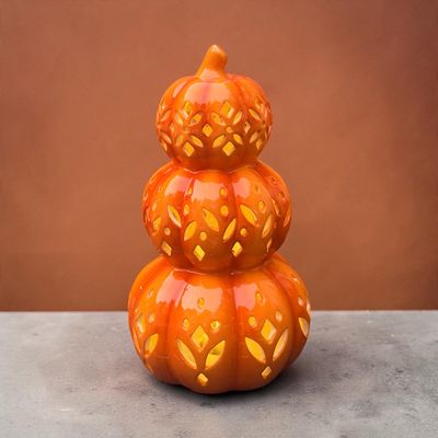 Sale Photo Thumbnail #32: Stacked three-tier ceramic pumpkin lantern with decorative lattice cutouts and a glossy orange finish.