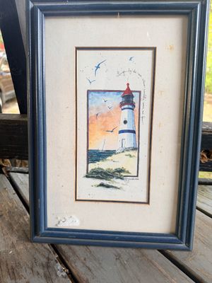 Sale Photo Thumbnail #63: Framed lighthouse watercolor print by Morgan Evans, featuring a coastal scene with a poetic inscription and double-matted blue wooden frame.