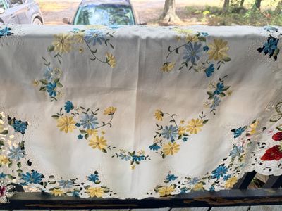 Sale Photo Thumbnail #52: Vintage white embroidered tablecloth featuring blue and yellow daisy motifs with cutwork eyelet trim.
