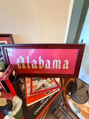 Sale Photo Thumbnail #40: Framed University of Alabama wordmark shadowbox display in a dark wood frame alongside various sports collectibles and magazines.
