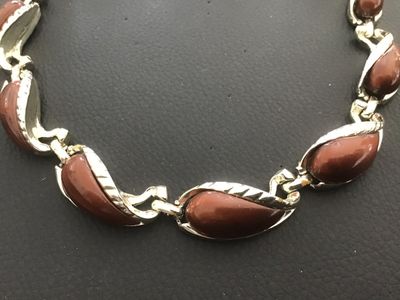 Sale Photo Thumbnail #25: Vintage gold-tone link necklace featuring paisley/tear-drop shaped links inset with smooth brown enamel or lucite cabochons and textured leaf trim detailing. Features a fold-over clasp mechanism. Measures approximately 15 to 16 inches in total length. Goo