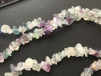 Sale Photo Thumbnail #85: Continuous strand gemstone chip necklace featuring polished natural fluorite chips in shades of purple, green, teal, and clear/white. Measures approximately 32 inches in length. In good pre-owned condition with natural inclusions and variation in the ston