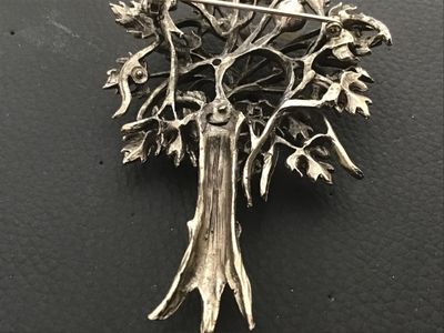 Sale Photo Thumbnail #99: Vintage silver-tone brooch designed in the shape of a tree, featuring detailed foliage with an antiqued or oxidized finish and single faux pearl accent. Includes a rollover safety clasp on the back. Measures approximately 2.25 to 2.5 inches in length. In 