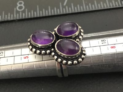 Sale Photo Thumbnail #179: Silver tone Statement Ring featuring three oval cabochon amethyst stones set in beaded, beaded-edge settings. Features a split-style band. Ring size appears to be approximately 6.5 based on the mandrel in photos. Good pre-owned condition with slight surfa
