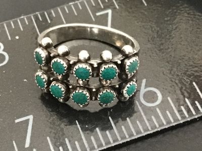 Sale Photo Thumbnail #250: Vintage Native American style / Southwestern sterling silver ring featuring a double row of serrated bezel-set turquoise cabochons (snake eye design) accented with silver raindrops. Stamped STERLING inside the band. Ring measures approximately size 7 on a