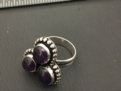 Sale Photo Thumbnail #181: Silver tone Statement Ring featuring three oval cabochon amethyst stones set in beaded, beaded-edge settings. Features a split-style band. Ring size appears to be approximately 6.5 based on the mandrel in photos. Good pre-owned condition with slight surfa