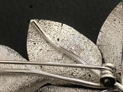 Sale Photo Thumbnail #24: Vintage silver-tone Giovanni brooch featuring an intricate botanical leaf spray design with textured vein details and delicate berry accents. Measures approximately 3 inches in length. Features a secure rollover safety clasp on the back. Stamped with the 
