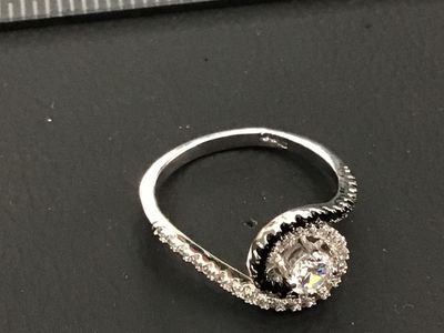 Sale Photo Thumbnail #184: silver bypass swirl ring featuring a central clear round cubic zirconia or crystal, surrounded by swirling bands of pave-set clear and black stones. Marked 925 on the inner band. Measures approximately size 9.5 on a ring mandrel. Good condition with light