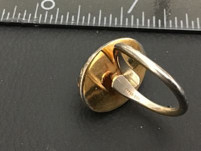 Sale Photo Thumbnail #264: Vintage Sarah Coventry costume ring featuring a large oval faux opal/dragon's breath glass cabochon in a crown-style gold-tone bezel setting. The band is adjustable and signed 'SARAH COV.' on the interior. Shows light age-appropriate wear and patina on me