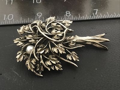 Sale Photo Thumbnail #100: Vintage silver-tone brooch designed in the shape of a tree, featuring detailed foliage with an antiqued or oxidized finish and single faux pearl accent. Includes a rollover safety clasp on the back. Measures approximately 2.25 to 2.5 inches in length. In 