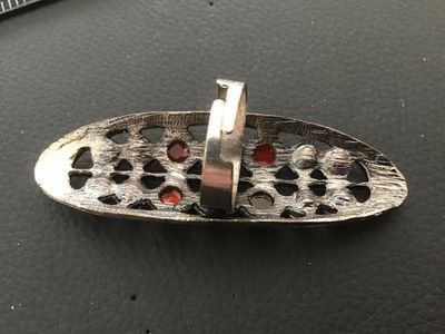 Sale Photo Thumbnail #80: Elongated statement ring featuring a textured silvertone openwork setting encrusted with faceted orange rhinestones and opaque orange cabochon/bead accents. Features an adjustable band on the back. The top measures approximately 2.5 inches in length. In g