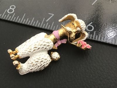 Sale Photo Thumbnail #15: Vintage gold-tone textured metal brooch featuring a French poodle figure with white textured enamel fur, a pink ribbon bow collar, and holding a pink enamel rose in its mouth. Measures approximately 2 inches long. Features a standard pin back clasp. Shows