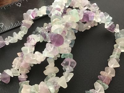 Sale Photo Thumbnail #83: Continuous strand gemstone chip necklace featuring polished natural fluorite chips in shades of purple, green, teal, and clear/white. Measures approximately 32 inches in length. In good pre-owned condition with natural inclusions and variation in the ston