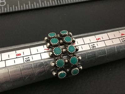 Sale Photo Thumbnail #247: Vintage Native American style / Southwestern sterling silver ring featuring a double row of serrated bezel-set turquoise cabochons (snake eye design) accented with silver raindrops. Stamped STERLING inside the band. Ring measures approximately size 7 on a