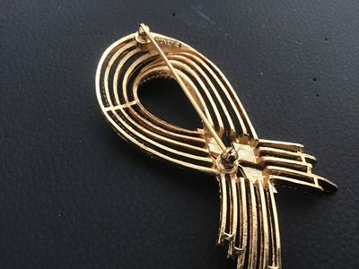 Sale Photo Thumbnail #13: Vintage Monet gold-tone brooch featuring textured, twisted rope strands in a modern abstract loop design with polished diamond-shaped central accents. Signed 'MONET ©' on the back. Measures approximately 2.75 inches long. Features a standard rollover saf