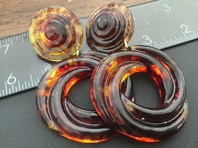 Sale Photo Thumbnail #47: Pair of statement clip-on drop earrings featuring a translucent faux tortoiseshell amber lucite/acrylic design with swirl pattern hoops and layered top buttons. Gold-tone clip backs with comfort pads. Total length is approximately 3 inches. Good vintage c