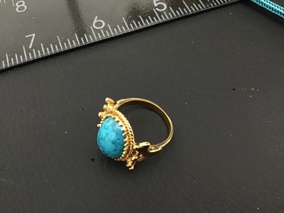 Sale Photo Thumbnail #259: Vintage gold tone statement ring featuring a large oval faux turquoise cabochon with a twisted rope textured border and ornate setting. Measures approximately size 6 on ring mandrel. Good vintage condition with light finish wear visible on the band.