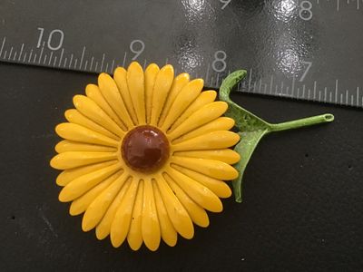 Sale Photo Thumbnail #92: A mid-century style vintage enamel brooch in the shape of a yellow flower with a brown center dome and green stem/leaves. Made of painted/enameled metal. Pin back attachment is intact. Measures approximately 3 inches across. Shows minor finish wear and li