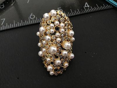 Sale Photo Thumbnail #227: An ornate gold-tone statement ring featuring a cluster of faux pearls, clear rhinestones, and blue accent stones in a lattice/mesh-style setting. An adjustable or open-back band design. Appears in good pre-owned condition with no missing stones visible.