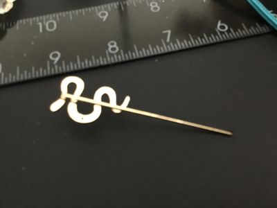 Sale Photo Thumbnail #215: Gold-tone metal stick pin featuring a serpentine snake design encrusted with clear pave rhinestones. Measures approximately 3 inches in total length. Good condition with all stones intact.
