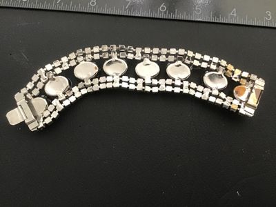 Sale Photo Thumbnail #41: Vintage wide costume jewelry bracelet featuring alternating faceted dark blue rhinestones and light blue opaque oval cabochons set between double rows of clear rhinestones. Silver-tone metal setting with a fold-over clasp. Measures approximately 7 inches 