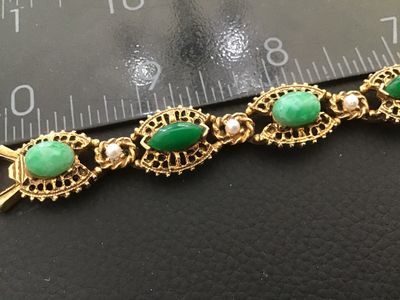 Sale Photo Thumbnail #10: A vintage signed Florenza gold-tone link bracelet featuring alternating oval and marquise-cut faux green jade cabochons, accented with small faux pearls between filigree-style ornate metal links. Measures approximately 7.25 inches in length. Marked 'FLORE