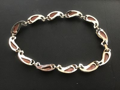 Sale Photo Thumbnail #27: Vintage gold-tone link necklace featuring paisley/tear-drop shaped links inset with smooth brown enamel or lucite cabochons and textured leaf trim detailing. Features a fold-over clasp mechanism. Measures approximately 15 to 16 inches in total length. Goo
