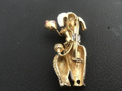 Sale Photo Thumbnail #17: Vintage gold-tone textured metal brooch featuring a French poodle figure with white textured enamel fur, a pink ribbon bow collar, and holding a pink enamel rose in its mouth. Measures approximately 2 inches long. Features a standard pin back clasp. Shows