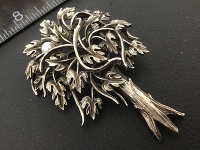 Sale Photo Thumbnail #96: Vintage silver-tone brooch designed in the shape of a tree, featuring detailed foliage with an antiqued or oxidized finish and single faux pearl accent. Includes a rollover safety clasp on the back. Measures approximately 2.25 to 2.5 inches in length. In 