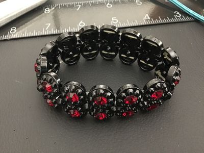Sale Photo Thumbnail #229: Vintage double-row stretch bracelet featuring black molded plastic round links set with faceted red rhinestones. The bracelet expands for easy wear and features a bold contrast style. Good pre-owned vintage condition with light surface wear.