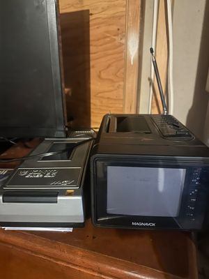 Sale Photo Thumbnail #30: Vintage Magnavox portable black-and-white television radio combo with telescoping antenna, accompanied by a silver Kinyo VHS tape rewinder.