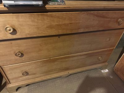 Sale Photo Thumbnail #26: Vintage light-finish wooden dresser featuring three wide drawers with matching carved wooden knobs.