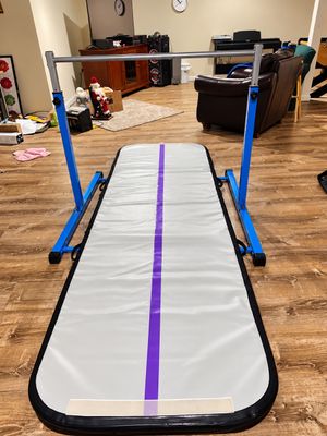 Sale Photo Thumbnail #8: Adjustable gymnastics horizontal bar with a blue metal frame paired with an inflatable gray and purple tumbling track mat.