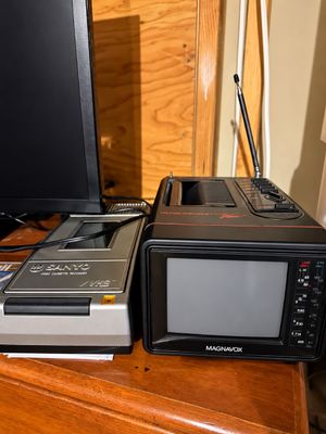 Sale Photo Thumbnail #2: Vintage Magnavox portable TV and radio unit with telescopic antenna, displayed alongside a Sanyo top-loading VHS video cassette recorder.