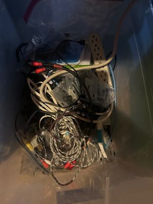 Sale Photo Thumbnail #27: Plastic storage tote filled with an assortment of electronic cables, power strips, and AV cords.