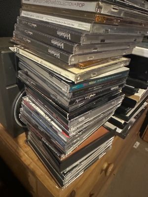 Sale Photo Thumbnail #24: Large stack of music CDs and recordable CD-Rs in jewel cases, featuring titles by Radiohead, Eminem, and Disney.