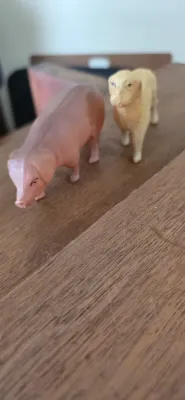 Sale Photo Thumbnail #83: Two vintage molded plastic farm animal figurines, featuring a pink pig and a light brown sheep, standing on a wooden surface.