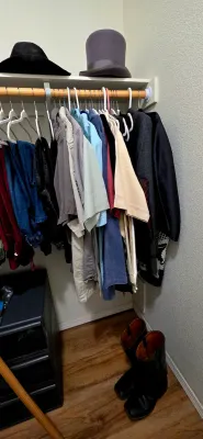 Sale Photo Thumbnail #55: Closet rack featuring an assortment of men's clothing, including button-up shirts, jackets, black boots below, and top hats displayed on the shelf above.