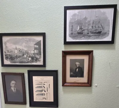 Sale Photo Thumbnail #76: Collection of framed vintage art and historical prints, including a portrait of a gentleman, nautical scenes, and an architectural diagram, presented in black and wooden frames.