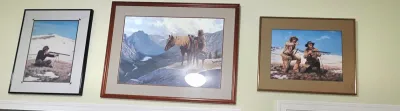 Sale Photo Thumbnail #56: Trio of framed Western and mountain wilderness art prints featuring figures with horses and rifles.