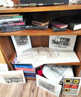 Sale Photo Thumbnail #61: Wooden bookcase filled with antique books, martial arts DVDs, engineering textbooks, and various vintage art prints and maps.