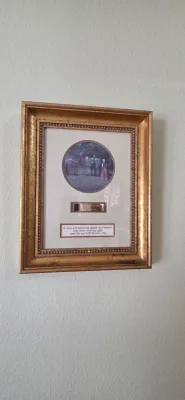 Sale Photo Thumbnail #81: Framed artwork titled "The Proposal," featuring a circular print above a brass title plaque and a scripture quote, set in a gilded frame.