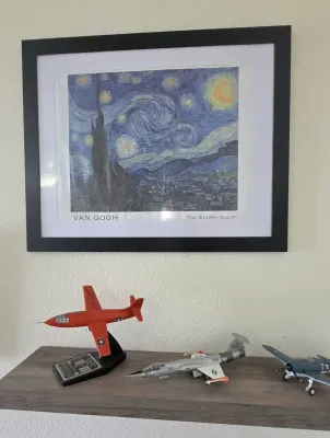 Sale Photo Thumbnail #48: Framed Van Gogh "The Starry Night" art print hanging above a wooden shelf displaying three detailed scale model airplanes.